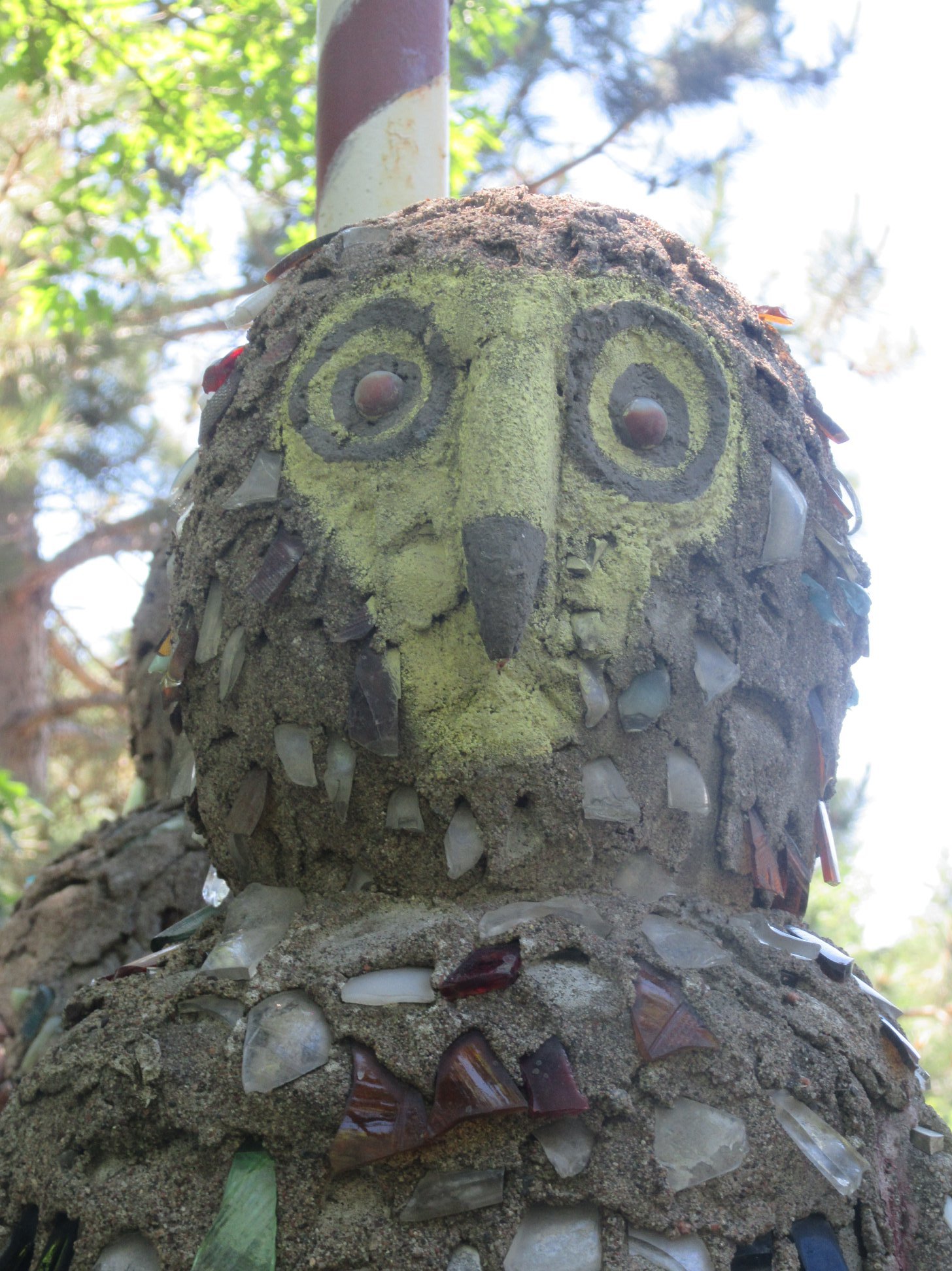 the scariest concrete and broken beer bottle owl you have ever seen in your life