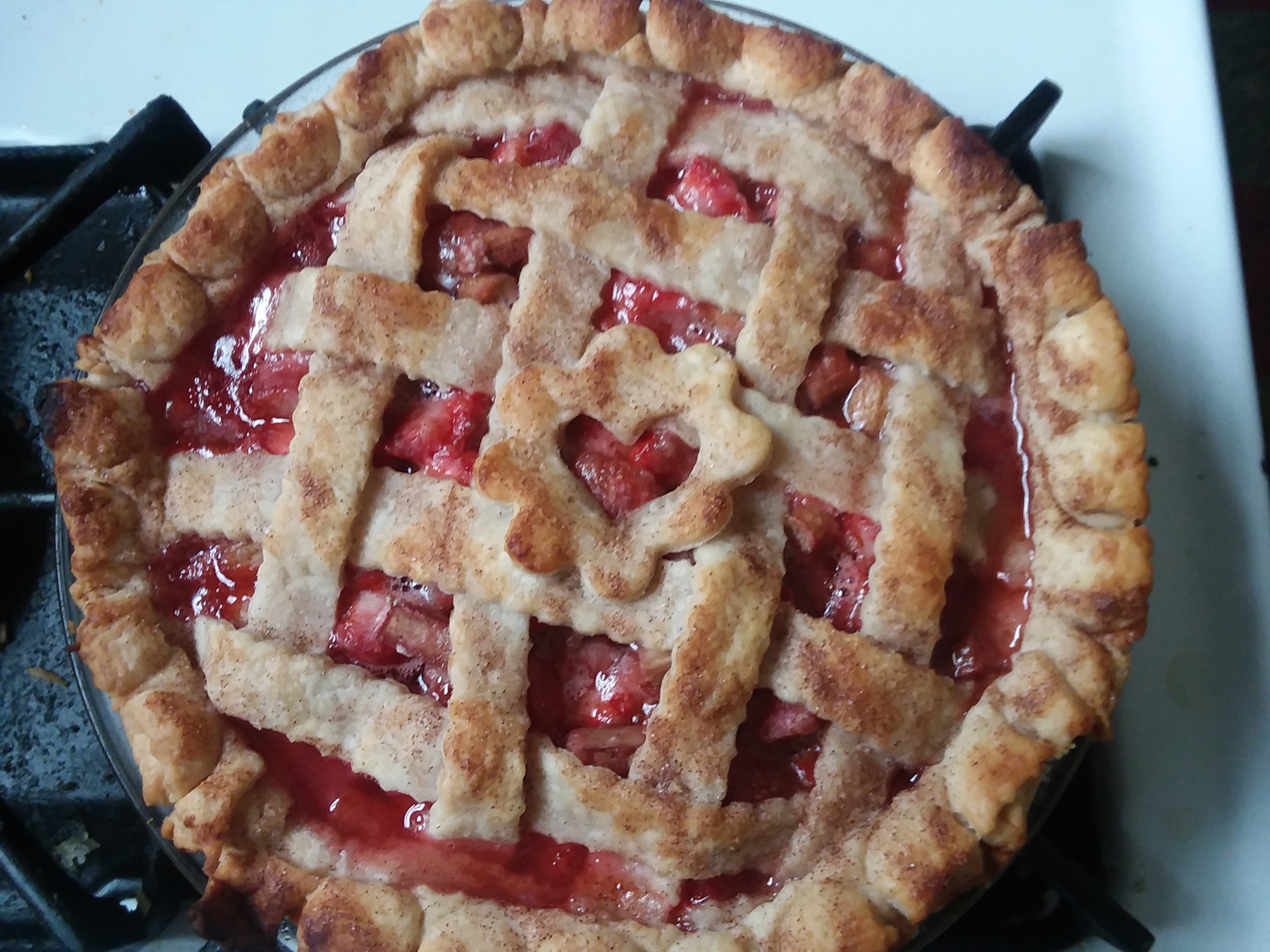 a bubbly red rhubarb and strawberry pie with lattice work top