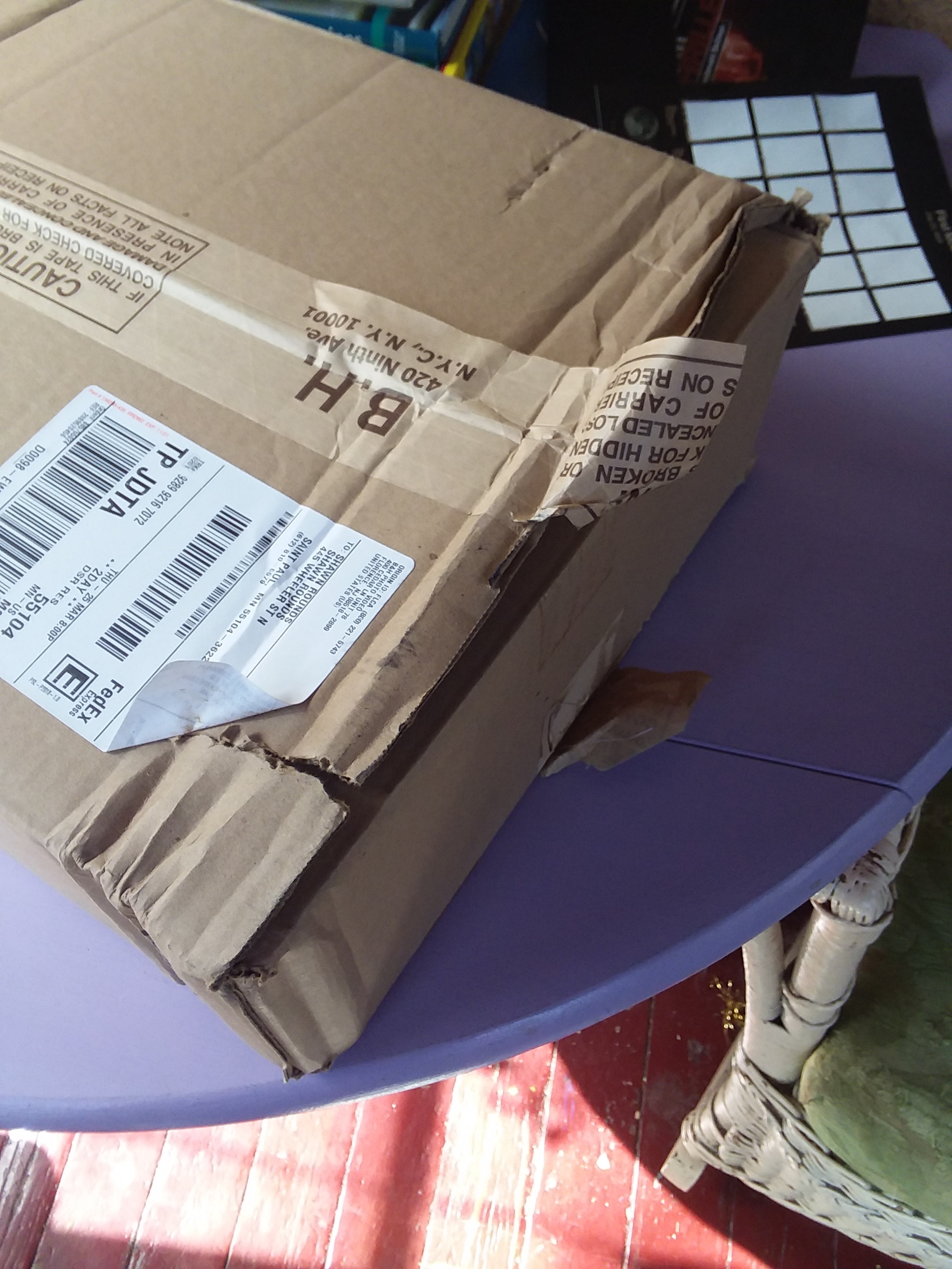 a cardboard box that has seen better days... unfortunately, on the inside is thousands of dollars worth of a new laptop.