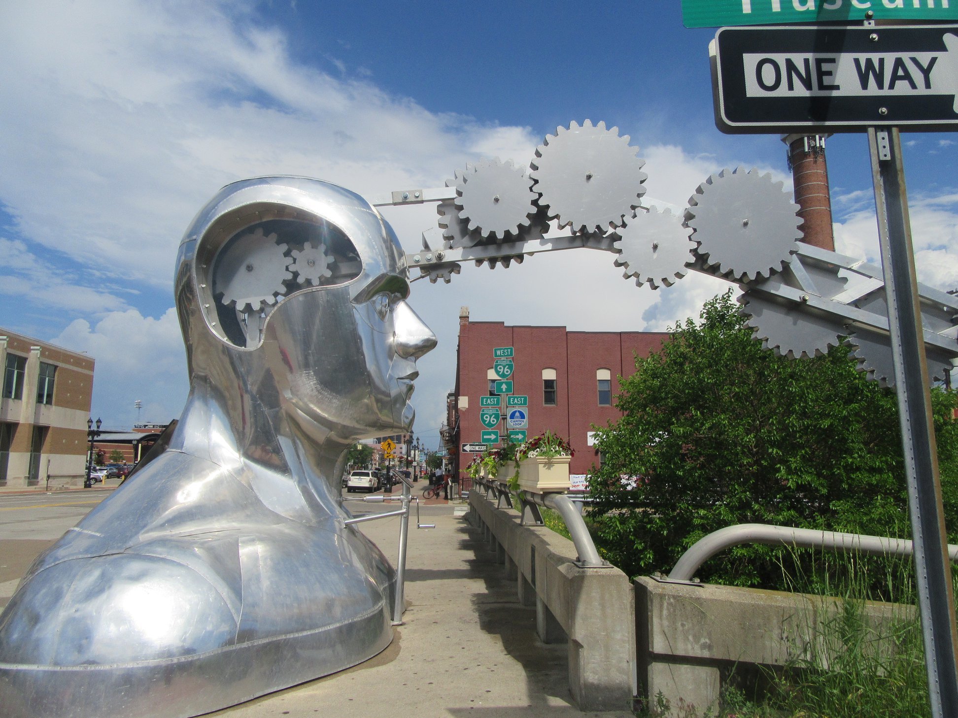 a giant, bald metal head spouting gears.