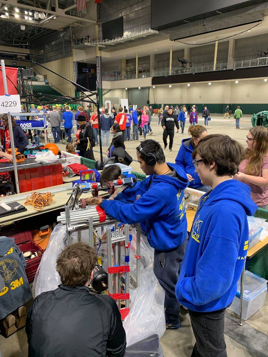 Standing around watching a robot be unwrapped