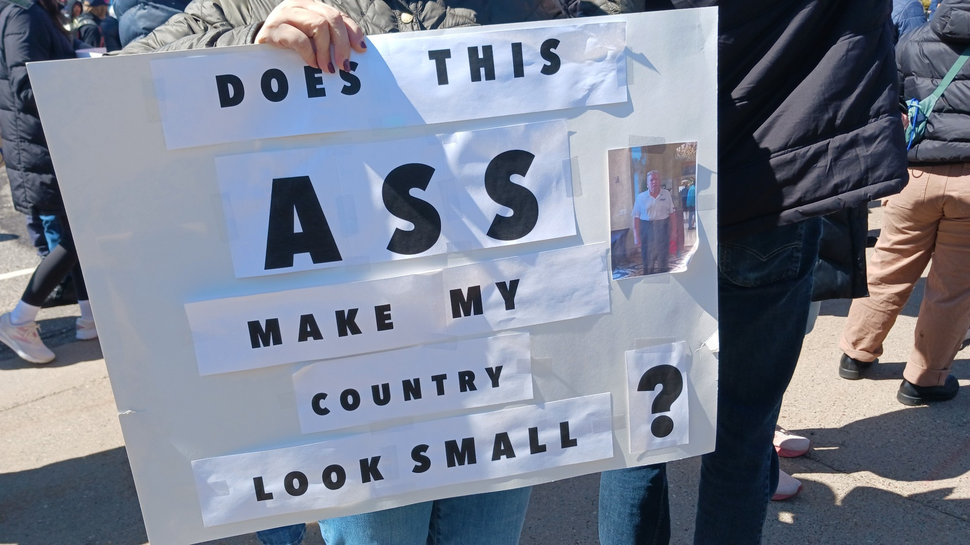 Sign that says, "Does this ASS" (picture of Trump in his grampa pants) "Make my Country Look Small?"